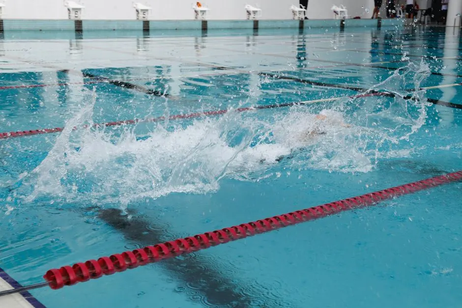 Vibrant action shot capturing water splash in a swimming pool racing lane.